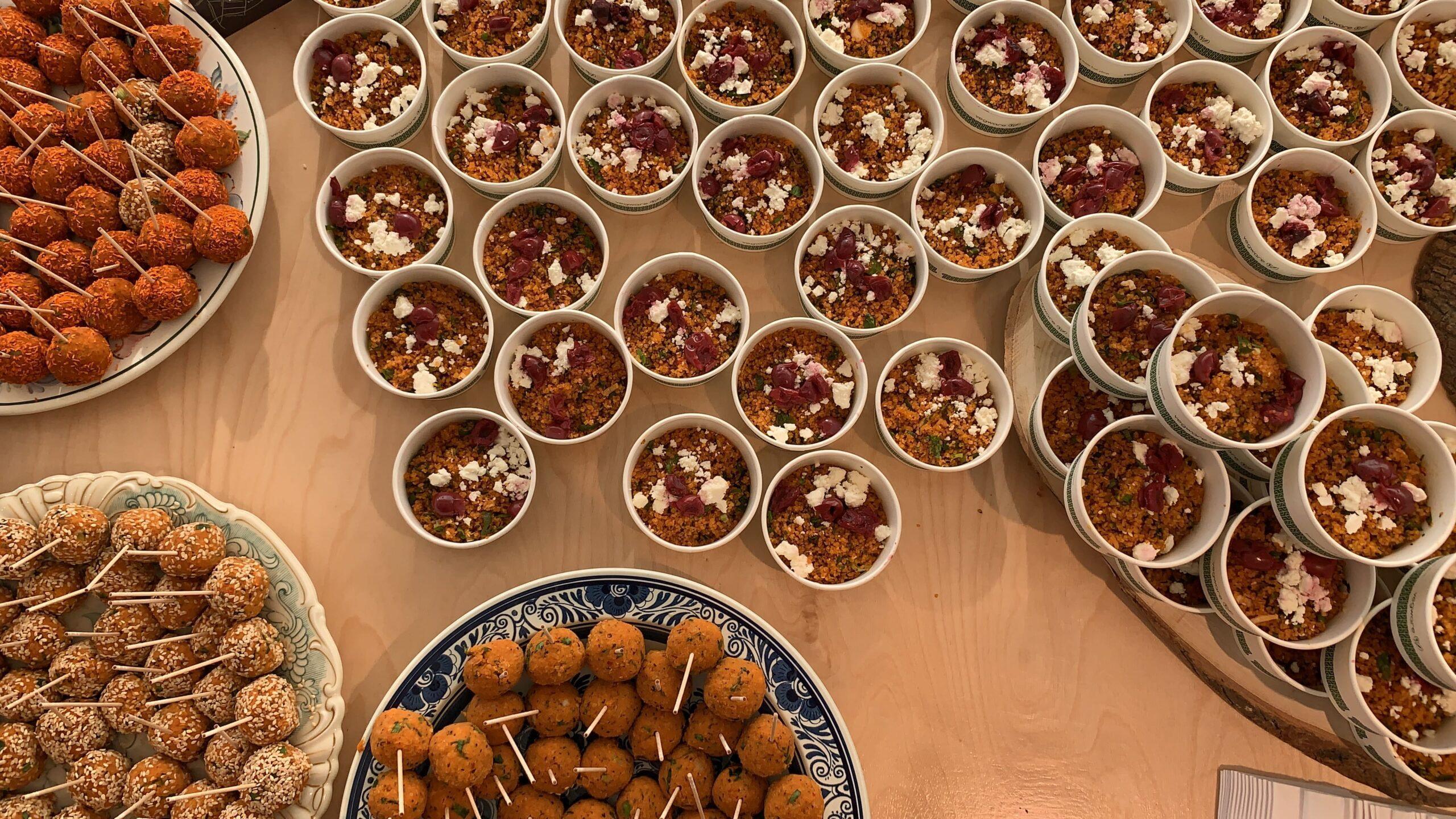 Couscous in Schalen und Fingerfood Bälle stehen auf einem Tisch bereit