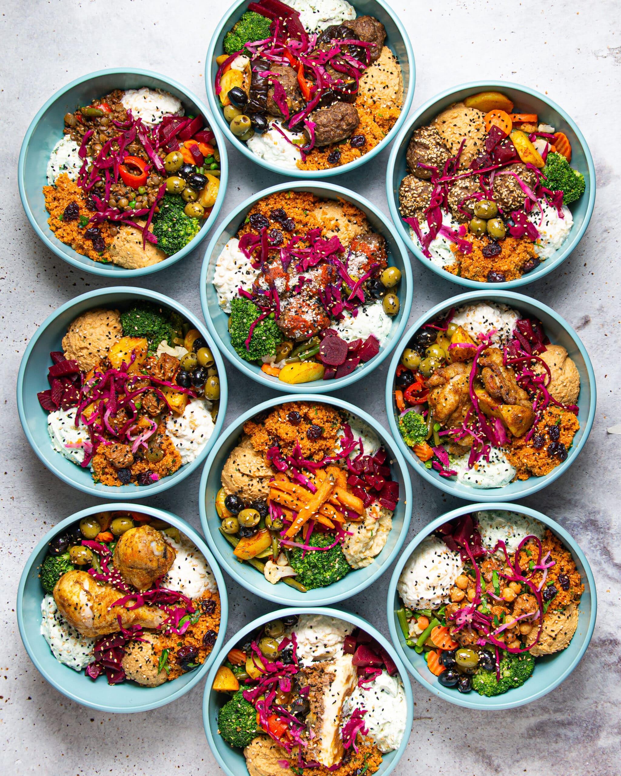 Auswahl an mediterranen Bowls mit Gemüse, Falafel und Gewürzen.
